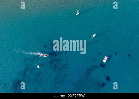 Drohnenantenne von angedockten Booten und Motor-Schnellboot im türkisfarbenen Wasser Zyperns Stockfoto