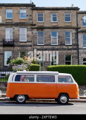Der klassische VW-Camper-Van in Orange und weiß parkte am 03. August 2024 in einer Wohnstraße in Edinburgh, schottischer Hauptstadt Stockfoto