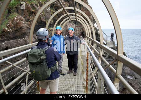 Touristen posieren für Fotos auf der Röhrenbrücke auf dem Gobbins Coastal Walk County antrim, Nordirland, großbritannien Stockfoto