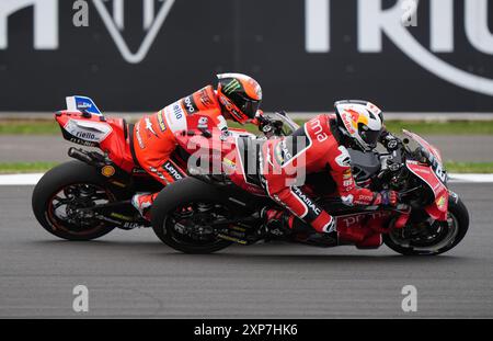 Francesco Bagnaia des Ducati Lenovo Teams wird während des Monster Energy British Grand Prix MotoGP 2024 in Silverstone, Towcester, von Jorge Martin von Prima Pramac Racing überholt. Bilddatum: Sonntag, 4. August 2024. Stockfoto