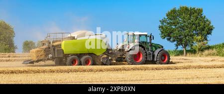 Traktor mit Strohballenpresse auf dem geernteten Feld - 8383 Stockfoto