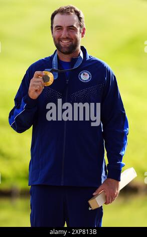 Der US-amerikanische Scottie Scheffler mit seiner Goldmedaille nach der 4. Men's Individual Stroke Play Round im Le Golf National am neunten Tag der Olympischen Spiele 2024 in Frankreich. Bilddatum: Sonntag, 4. August 2024. Stockfoto