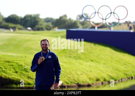 Der US-amerikanische Scottie Scheffler mit seiner Goldmedaille nach der 4. Men's Individual Stroke Play Round im Le Golf National am neunten Tag der Olympischen Spiele 2024 in Frankreich. Bilddatum: Sonntag, 4. August 2024. Stockfoto