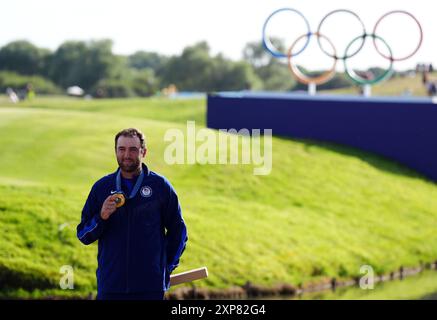 Der US-amerikanische Scottie Scheffler mit seiner Goldmedaille nach der 4. Men's Individual Stroke Play Round im Le Golf National am neunten Tag der Olympischen Spiele 2024 in Frankreich. Bilddatum: Sonntag, 4. August 2024. Stockfoto