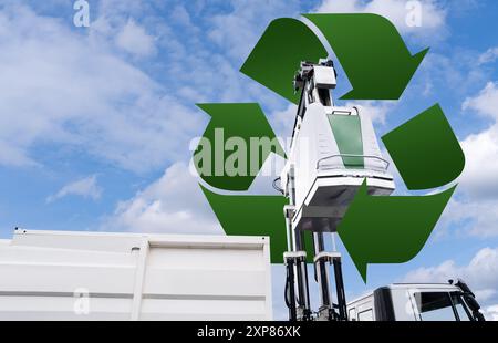 Müllwagen hebt den Straßenbehälter für recycelbaren Abfall an. Stockfoto