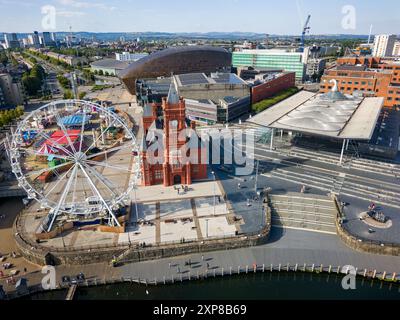 CARDIFF, WALES - 29. JULI 2024: Aus der Vogelperspektive auf das Pierhead-Gebäude der Cardiff Bay, das Rad und die Sommerattraktionen des Messegeländes Stockfoto