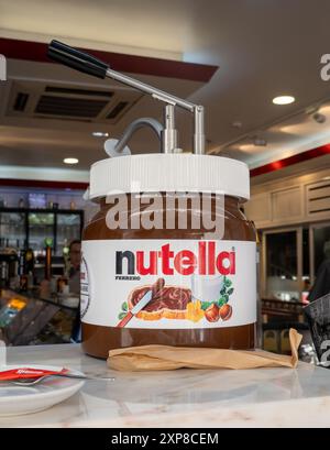 Riesiges Glas Nutella mit beheiztem Pumpspender in Einem Café in Lissabon, mit dem Nutella auf Desserts gegossen wurde Haselnussverbreitung 16. April 2024 Stockfoto