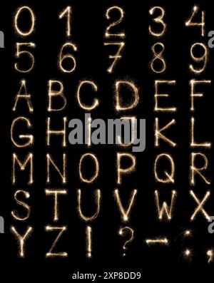 Englische Buchstaben von Sparklern, Alphabet und Zahlen auf schwarzem Hintergrund. Stockfoto