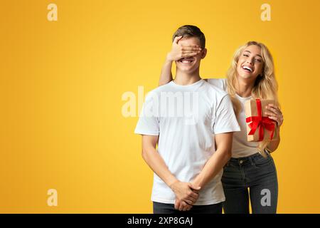 Mädchen die Augen ihres Freundes und Ihm vorhanden Stockfoto