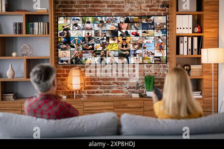 Paare schauen Fernsehen im Wohnzimmer mit Ziegelwand Stockfoto