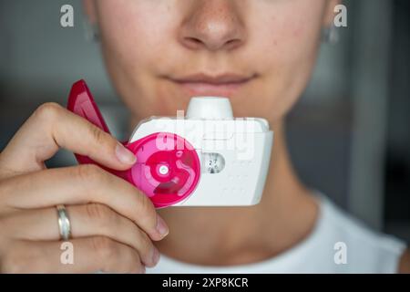 Nahaufnahme der Frau mit Medizin Trockenpulver Inhalator für die Behandlung von Asthma oder COPD-Erkrankungen. Pharmazeutisches Produkt wird zur Behandlung der Lunge verwendet Stockfoto