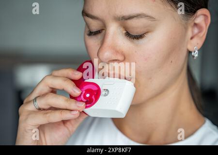 Nahaufnahme der Frau mit Medizin Trockenpulver Inhalator für die Behandlung von Asthma oder COPD-Erkrankungen. Pharmazeutisches Produkt wird zur Behandlung der Lunge verwendet Stockfoto
