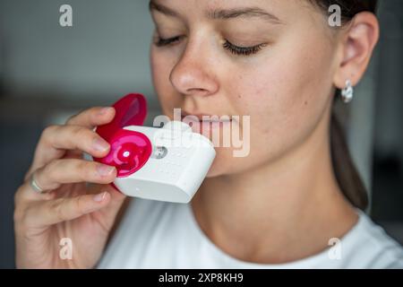 Nahaufnahme der Frau mit Medizin Trockenpulver Inhalator für die Behandlung von Asthma oder COPD-Erkrankungen. Pharmazeutisches Produkt wird zur Behandlung der Lunge verwendet Stockfoto