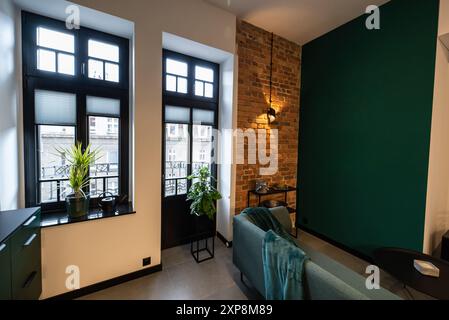 Stilvolle Küche, die nahtlos mit einem gemütlichen Wohnzimmer verbunden ist. Moderne Küche, verbunden mit dem Wohnzimmer in einem kleinen Apartment. Modern eingerichtete Küche Stockfoto