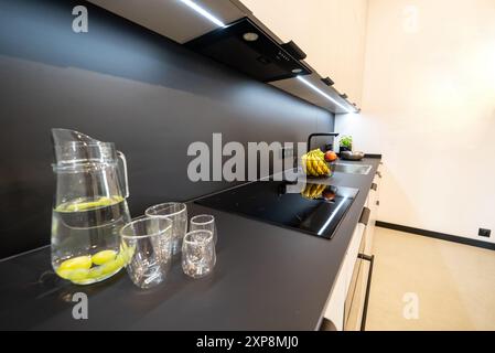 Modern eingerichtete Küche mit Haushaltsgeräten und Esszimmer. Innenraum einer modernen Küche in einem neuen Haus. Esstisch und Stühle in stilvoller Ausführung Stockfoto