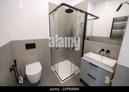 Das moderne Badezimmer verfügt über elegante Fliesenwände und Betonfußboden. Innenausstattung eines modernen Badezimmers mit Fliesenwänden und Beton. Modern Stockfoto