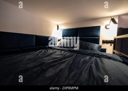 Modernes Studio-Apartment mit einem Schlafzimmer im Zwischengeschoss. Das Innere eines Hotelschlafzimmers mit Bett und Kissen. Kleines und modernes Apartment mit Zwischengeschoss Stockfoto