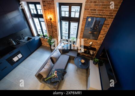 Stilvolle Küche, die nahtlos mit einem gemütlichen Wohnzimmer verbunden ist. Moderne Küche, verbunden mit dem Wohnzimmer in einem kleinen Apartment. Modern eingerichtete Küche Stockfoto