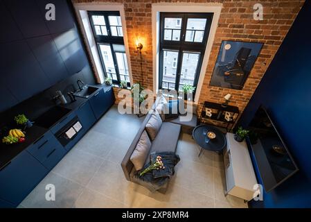 Stilvolle Küche, die nahtlos mit einem gemütlichen Wohnzimmer verbunden ist. Moderne Küche, verbunden mit dem Wohnzimmer in einem kleinen Apartment. Modern eingerichtete Küche Stockfoto