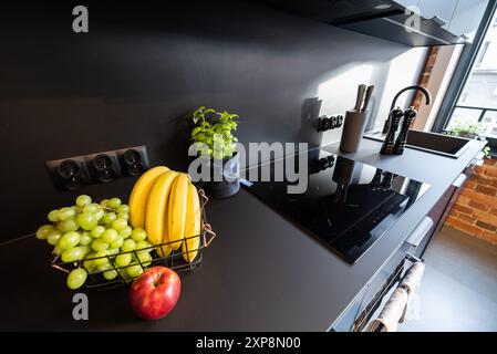 Modern eingerichtete Küche mit Haushaltsgeräten und Esszimmer. Innenraum einer modernen Küche in einem neuen Haus. Esstisch und Stühle in stilvoller Ausführung Stockfoto