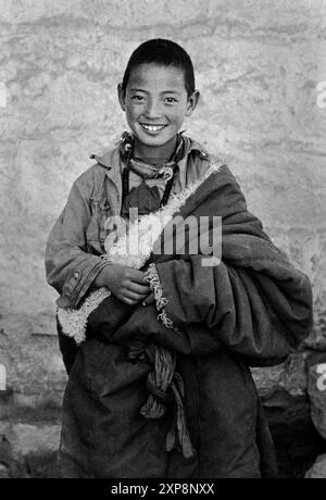 Ein junger Mönch trägt eine Schafhaut Chuba im Sera Monasterty in Lhasa Tibet - 1986 Stockfoto