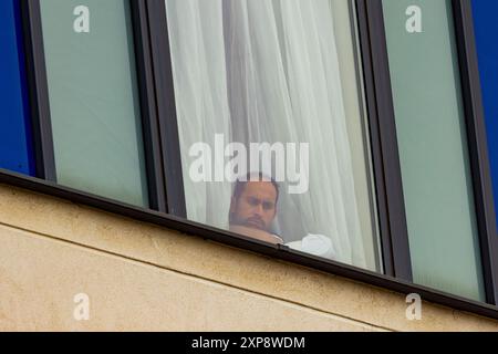 Rotherham, Großbritannien. AUGUST 2024. Die im Hotel untergebrachten Personen blicken aus den Fenstern auf die Menschenmenge, während Hunderte von Polizisten und Demonstranten vor einem Holiday Inn Express am Manvers Way, Rotherham, aufeinander treffen. Die Demonstranten des rechten Flügels, die von Sir Kier Starmer als „Gangster“ beschrieben wurden, zündeten Eigentum an, zerschlugen Glas und kämpften mehrere Stunden mit der Polizei. Mehrere Verhaftungen und Verletzungen von Aufständischen und Polizei. Credit Milo Chandler/Alamy Live News Stockfoto