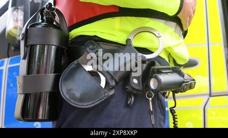 Handschellen und PAVA-Spray am Gürtel eines Polizisten Stockfoto