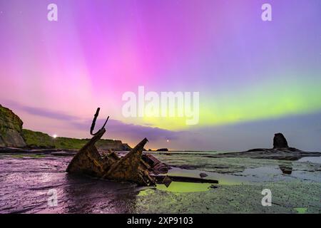 Northern Lights in Saltwick Bay, nahe Whitby, North Yorkshire am Freitag, den 10. Mai 2024, der größte geomagnetische Sturm seit zwei Jahrzehnten Stockfoto