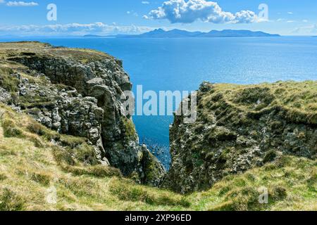 Die Isle of Rum von der Küstenklippe aus unterhalb von Beinn an Eòin auf der Nordseite von Glen Brittle, Isle of Skye, Schottland, Großbritannien Stockfoto