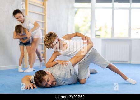 Vater lehrt seinen Sohn, in Selbstverteidigungskursen kraftvolle Techniken und Griffe anzuwenden Stockfoto
