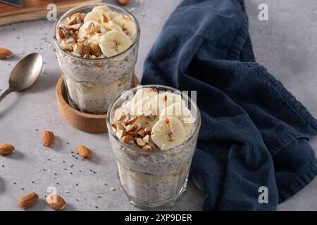 Haferflocken in Gläsern mit Bananenscheiben und Mandeln. Stockfoto