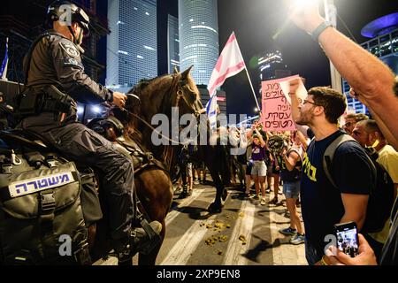 Tel Aviv, Israel. August 2024. Israelische Polizeibeamte blockieren Demonstranten während der Demonstration. Während Israel nach den Ermordungen des Hamas-Führers Ismail Haniyah in Teheran und des hochrangigen Hezbollah-Kommandeurs Fuad Shukr in Beirut auf mögliche Vergeltungsmaßnahmen seitens Iran und der Hisbollah vorbereitet ist, Familien israelischer Geiseln, die von der Hamas in Gaza festgehalten werden, begehen den 300. Tag seit dem Massaker vom 7. Oktober und der Entführung ihrer Angehörigen. Die Familien fordern eine Freilassung von Geiseln mit 115 Geiseln, von denen einige tot und andere lebendig sind, die noch immer in Gaza festgehalten werden. Quelle: SOPA Images Limited/Alamy Live News Stockfoto