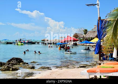 Urlauber, die an einem sonnigen Sommertag am Secret Beach, San Pedro, Belize entspannen und schwimmen. Stockfoto
