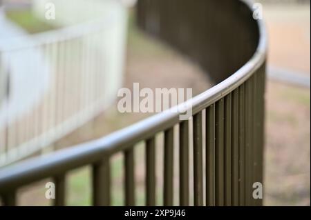 Präsentieren Sie ein geschwungenes Geländer in moderner Architektur, das die glatten Linien und die einzigartige optische Wirkung im Vergleich zu starren geraden Linien unterstreicht. Stockfoto