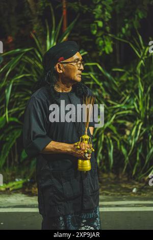 Balikpapan, Indonesien - 5. Juni 2024. Er hält einen Räucherstäbchen mit Räucherstäbchen Stockfoto