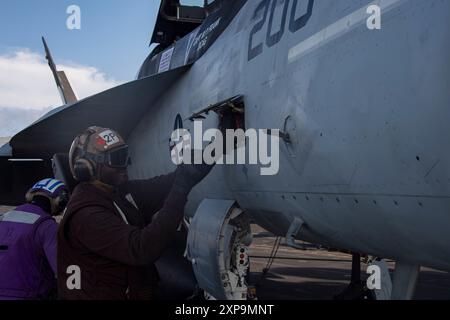 240722-N-IJ966-1097 PAZIFISCHER OZEAN (22. Juli 2024) Airman Apprentice Jason Wilson aus Montego Bay, Jamaika, führt Wartungsarbeiten an einer F/A-18E Super Hornet durch, die der Strike Fighter Squadron (VFA) 14 zugewiesen wurde, auf dem Flugdeck des Flugzeugträgers USS Abraham Lincoln der Nimitz-Klasse (CVN 72). Abraham Lincoln, das Flaggschiff der Carrier Strike Group Three, führt im Einsatzgebiet der 3. US-Flotte Routineoperationen durch. Als integraler Bestandteil der US-Pazifik-Flotte betreibt die 3. US-Flotte Marinekräfte im Indo-Pazifik, zusätzlich zu realistischen und r Stockfoto