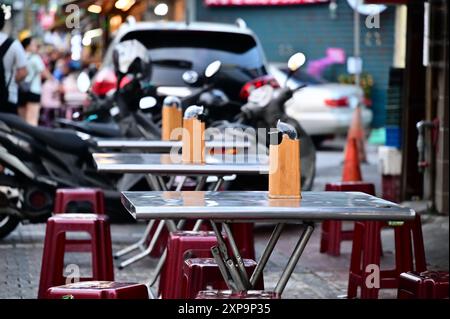 Taiwan - 3. August 2024: Erleben Sie die lebendige Street Food-Kultur Asiens mit Sitzplätzen am Straßenrand, die eine Vielfalt an traditionellen und internationalen Angeboten bieten. Stockfoto