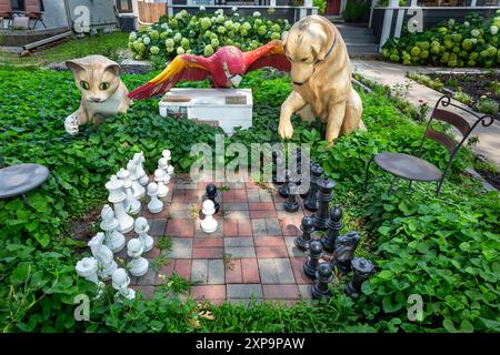 Eine anthropomorphe Szene, in der Tiere dargestellt werden – eine Katze, ein Papagei und ein Hund, der im Freien Schach spielt, im Süden von Minneapolis, Minnesota. Stockfoto