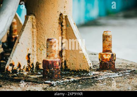 Rostige Schrauben, die eine Metallkonstruktion halten, zeigen Korrosion, ein häufiges Problem in der Ingenieurbranche. Stockfoto