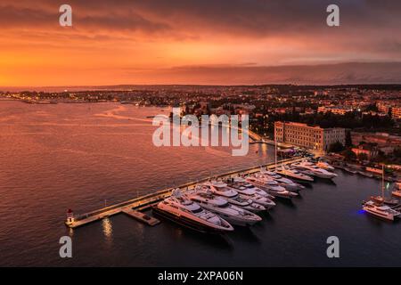 Zadar, Kroatien - Blick aus der Luft auf einen wunderschönen goldenen Sonnenuntergang über der Stadt Zadar mit Yachthafen an einem Sommernachmittag. Warme, dramatische Lichter am Stockfoto