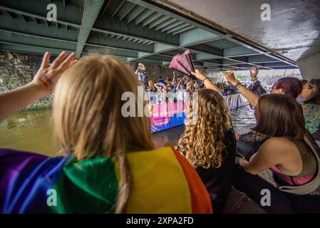 Wohlwollende jubeln vorbeifahrende Boote unter einer Brücke an, während der GEMEINSAM - Chanal Boat Pride. Der Amsterdamer „Chanal Boat Pride - Together“ ist einer der wichtigsten Höhepunkte des Amsterdamer Kalenders und kann rund 500.000 Menschen anziehen. Dies war die 27. Ausgabe. In diesem Jahr gab es 80 Boote, die am Mittag starteten und fünf bis sechs Stunden später ausliefen. Bei idealen Wetterbedingungen segelten sie vom Oosterdok über Nieuwe Herengracht, Amstel und Prinsengracht bis zum Westerdok. Viele Häuser waren in „Pride“-Farben dekoriert, mit einer stimmungsvollen und festlichen Atmosphäre entlang des Weges. Stockfoto