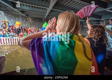 Wohlwollende jubeln vorbeifahrende Boote unter einer Brücke an, während der GEMEINSAM - Chanal Boat Pride. Der Amsterdamer „Chanal Boat Pride - Together“ ist einer der wichtigsten Höhepunkte des Amsterdamer Kalenders und kann rund 500.000 Menschen anziehen. Dies war die 27. Ausgabe. In diesem Jahr gab es 80 Boote, die am Mittag starteten und fünf bis sechs Stunden später ausliefen. Bei idealen Wetterbedingungen segelten sie vom Oosterdok über Nieuwe Herengracht, Amstel und Prinsengracht bis zum Westerdok. Viele Häuser waren in „Pride“-Farben dekoriert, mit einer stimmungsvollen und festlichen Atmosphäre entlang des Weges. Stockfoto