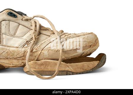 Gebrochener alter benutzter Schuh isolierter weißer Hintergrund, Teil von schmutzigen Sportschuhen oder Turnschuhen mit gebundener Spitze in Nahaufnahme mit Schatten Stockfoto