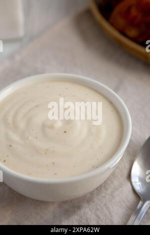 Hausgemachte weiße Alabama-Sauce für BBQ-Hühnchen-Drumsticks und -Flügel, Seitenansicht. Stockfoto