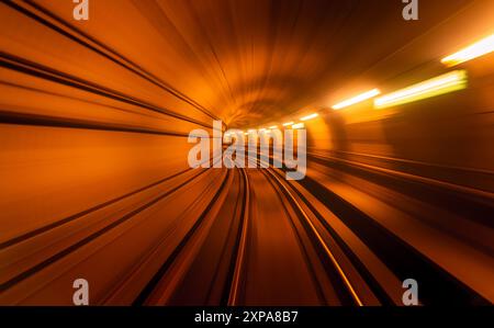 Ein Zug fährt durch einen langen Tunnel mit hellen Lichtern Stockfoto