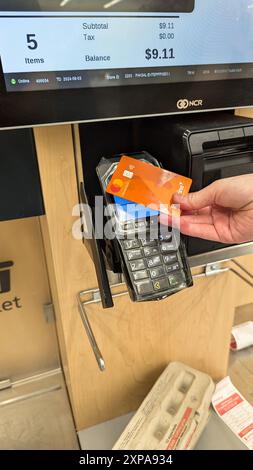 Eine Frau bezahlt mit einer Kreditkarte für ihre Sachen im Shoppers Drug Mart. Stockfoto