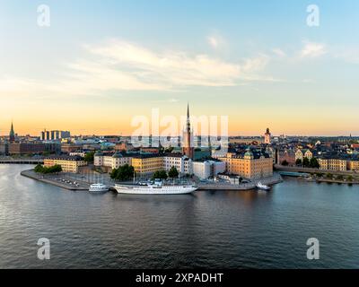 Aus der Vogelperspektive Gamla Stan, Altstadt in Stockholm bei Sonnenuntergang mit der Kirche Riddarholmskyrkan im Vordergrund und einem farbenfrohen Himmel Stockfoto