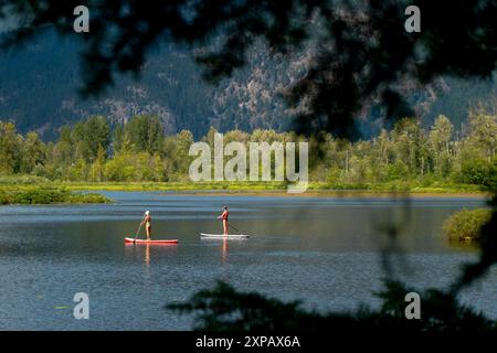 Zwei Frauen paddeln auf dem One Mile Lake, Pemberton, British Columbia, Kanada Stockfoto