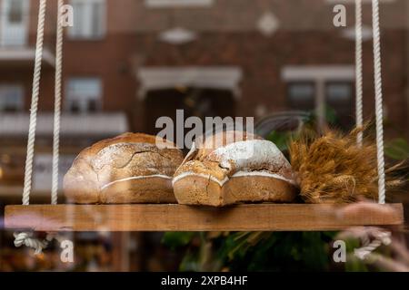 Handwerkliche Brote werden im Fenster der Bäckerei mit rustikaler Einrichtung ausgestellt Stockfoto