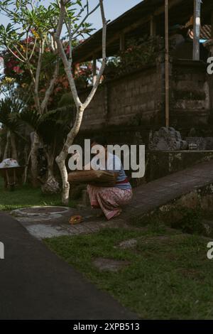 Frau, die betet und Geister opfert, Bali. Stockfoto